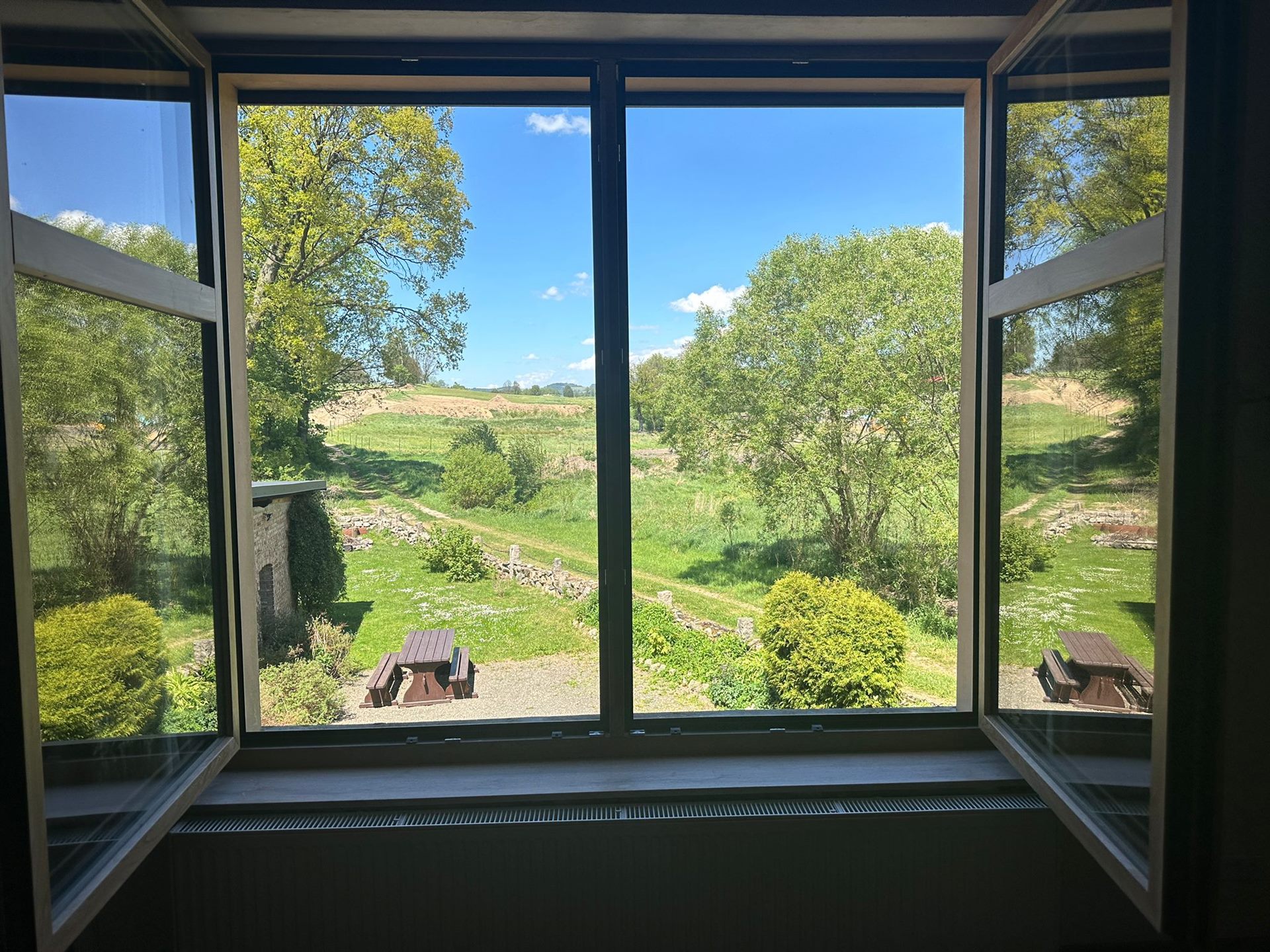 View of the garden through an open window at Domstolat