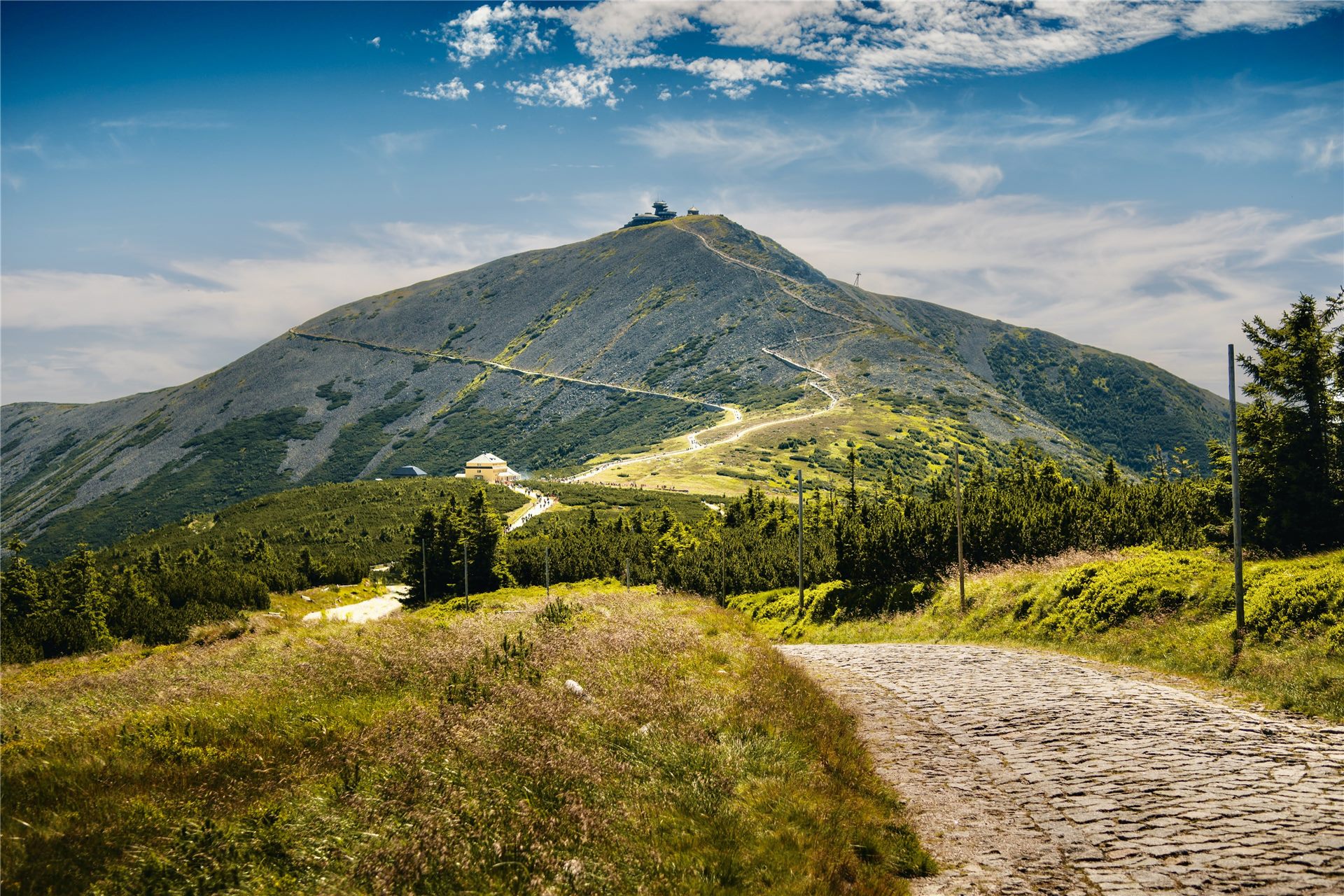 Paved mountain path through the Giant Mountains towards Śnieżka, with the observatory on the summit