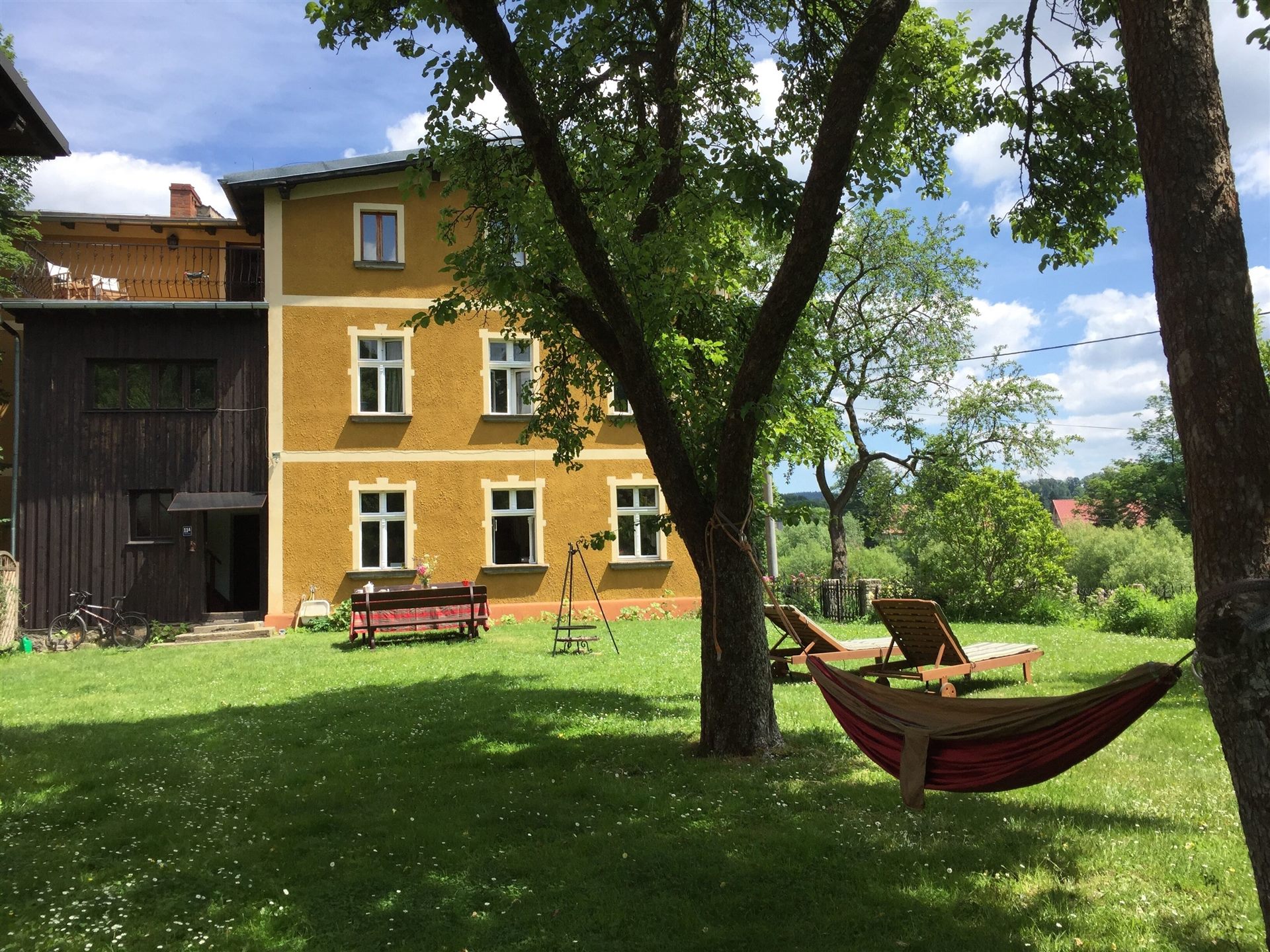Hammock and sun loungers under the apple tree in the garden at Domstolat